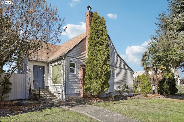 view of front of house featuring a chimney and a front yard