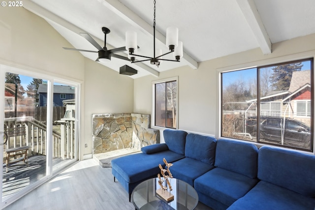 living area with lofted ceiling with beams, ceiling fan with notable chandelier, and wood finished floors