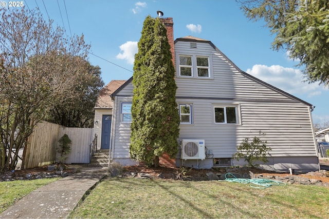 exterior space featuring entry steps, a lawn, a chimney, fence, and ac unit