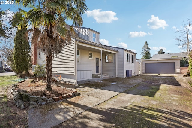 view of front of property with a detached garage and an outbuilding