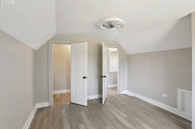 additional living space with lofted ceiling, baseboards, and wood finished floors