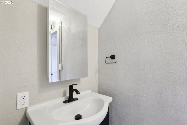 bathroom featuring a sink and a textured wall