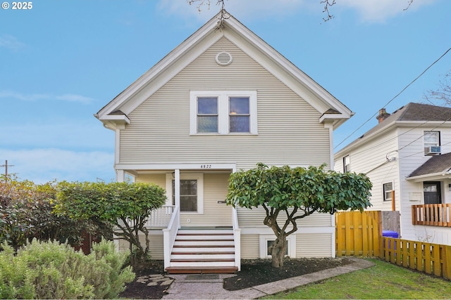 view of front of property featuring stairway, covered porch, and fence