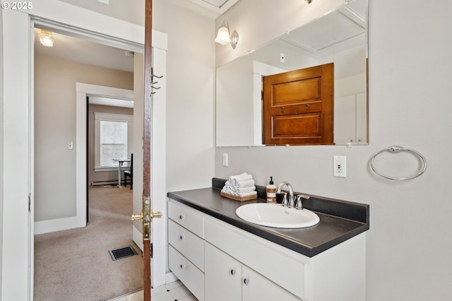 bathroom featuring vanity, baseboards, visible vents, and a baseboard heating unit