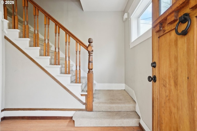 entrance foyer with stairs and baseboards