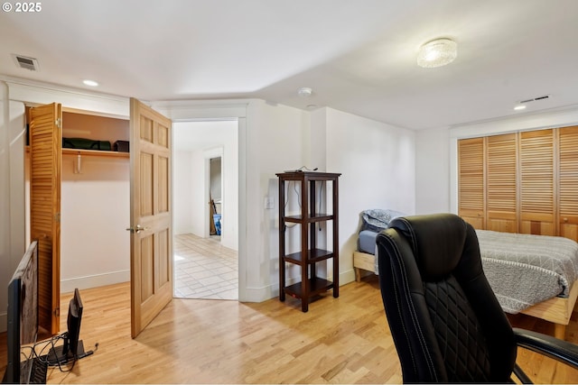 bedroom featuring a closet, visible vents, light wood-style flooring, and recessed lighting