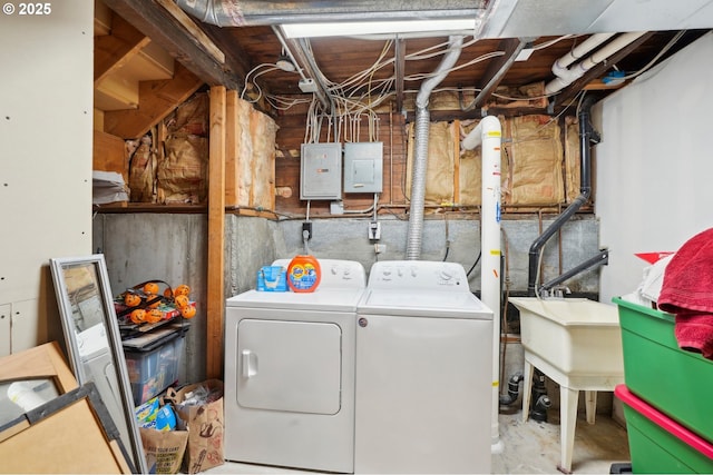 washroom with electric panel, laundry area, independent washer and dryer, and a sink