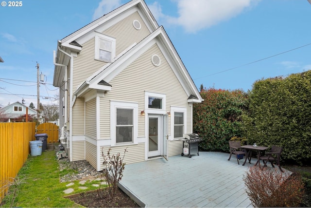 back of house featuring a deck, a yard, and fence