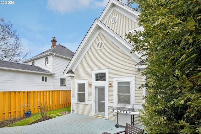 back of property with a deck and fence