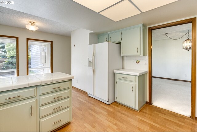 7430 SW Greens View Ct, Wilsonville, OR 97070 - kitchen featuring white appliances, a sink, a peninsula, light wood-type flooring, and tasteful backsplash