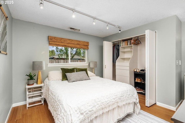 bedroom featuring light wood-style flooring, baseboards, and a closet