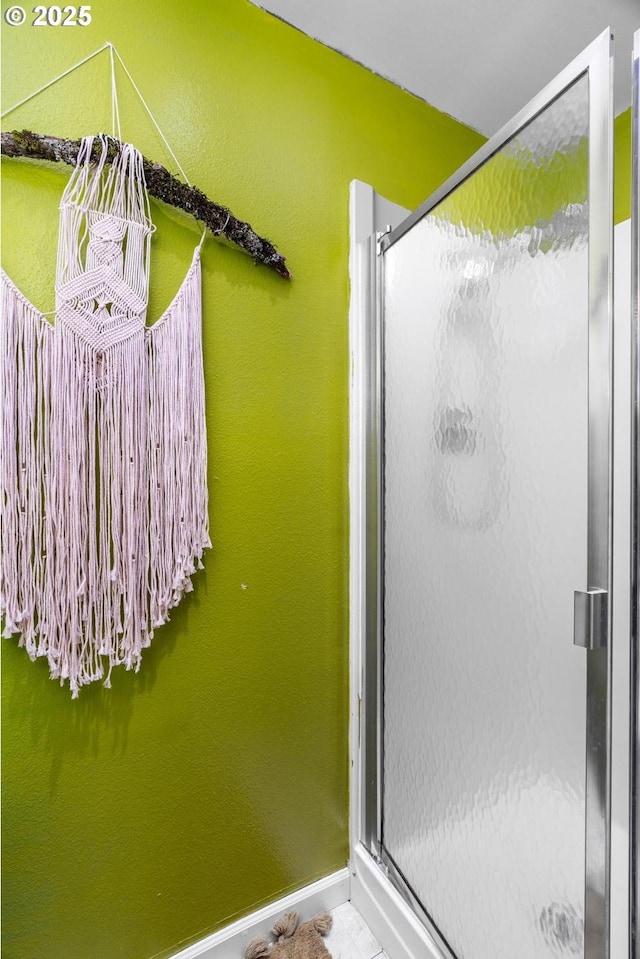 bathroom with a stall shower and baseboards