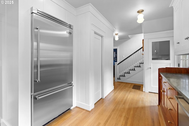 kitchen featuring visible vents, light wood-style flooring, appliances with stainless steel finishes, and white cabinets