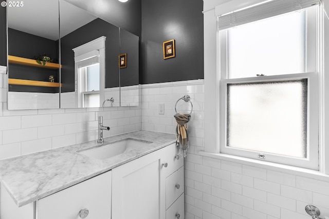bathroom featuring vanity, tile walls, and a wainscoted wall