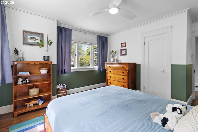 bedroom with baseboards, crown molding, a ceiling fan, and wood finished floors