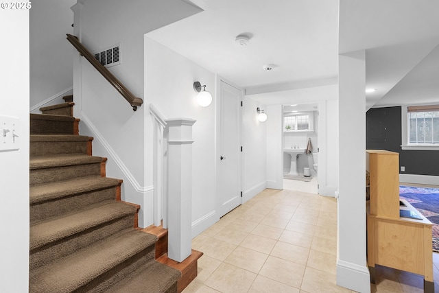 stairway featuring tile patterned flooring, baseboards, and visible vents