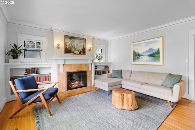 living room featuring a fireplace, crown molding, and wood finished floors