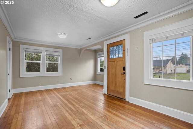 living room featuring ornamental molding, light wood-type flooring, and a textured ceiling