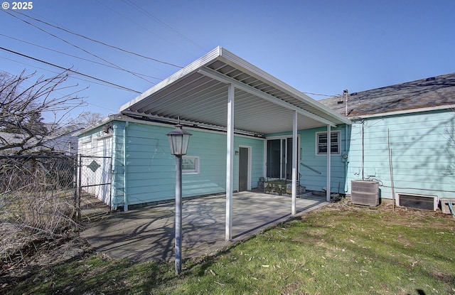 back of house featuring central AC, a patio, and a lawn