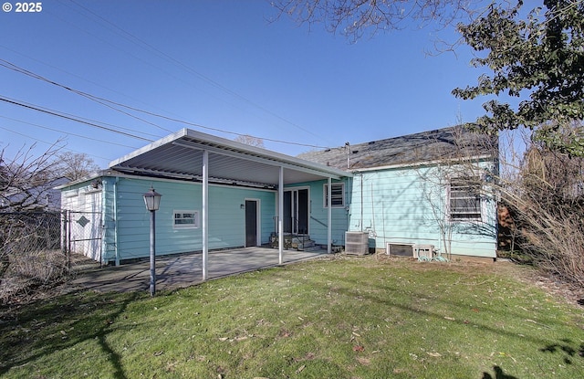 back of property with central AC, a lawn, and a patio area