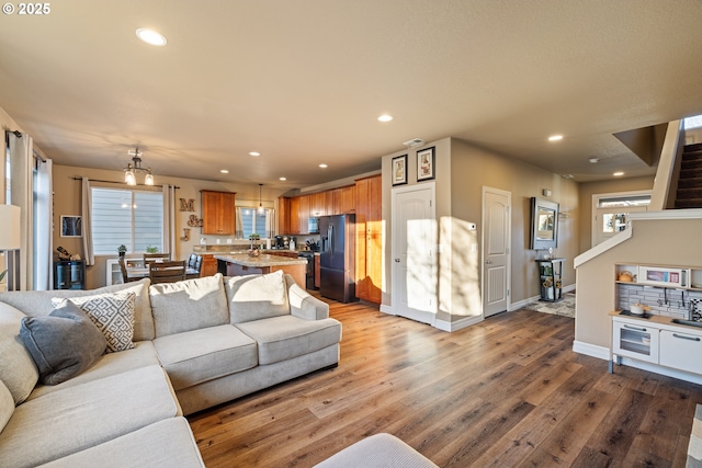 kitchen with black appliances, a kitchen island, brown cabinetry, and a sink