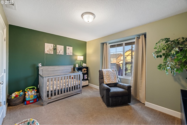 bedroom featuring a textured ceiling, a crib, carpet, and baseboards