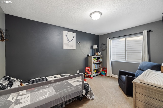 carpeted bedroom featuring baseboards and a textured ceiling