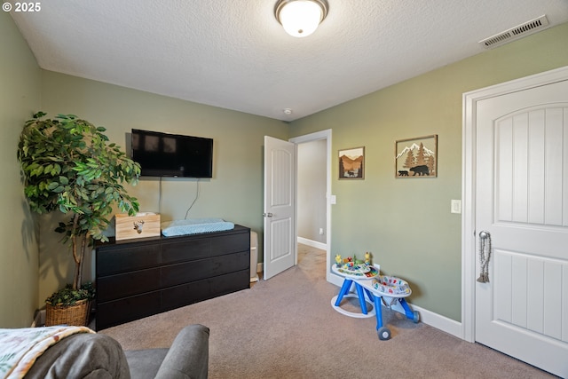 bedroom featuring a textured ceiling, carpet, visible vents, and baseboards