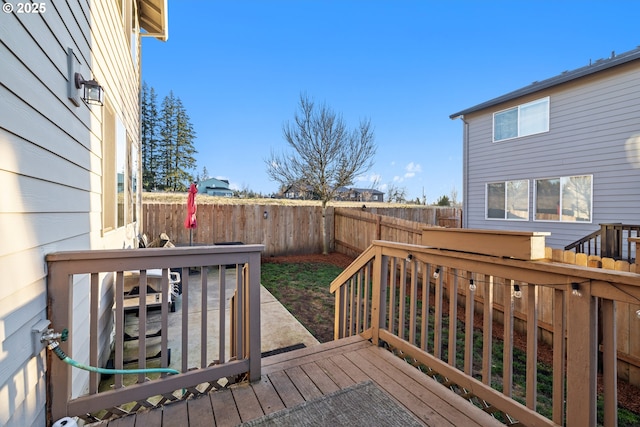 wooden deck with a fenced backyard