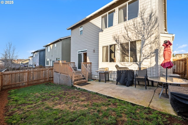 back of house featuring a wooden deck, fence, a lawn, and a patio