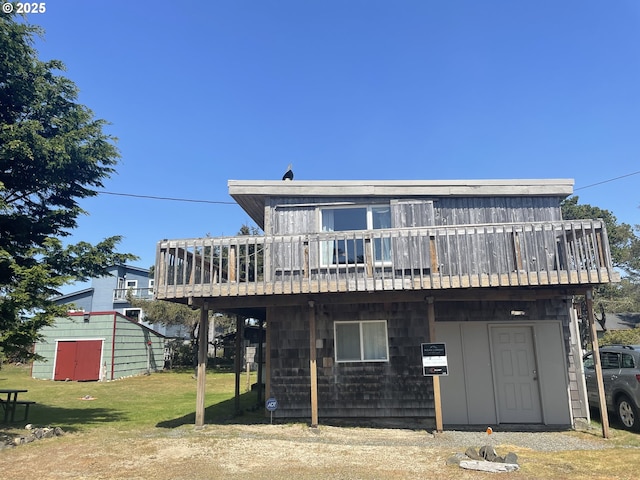 5870 Floyd Ave, Cloverdale, OR 97112 - rear view of house featuring a lawn, a deck, an outdoor structure, and a storage unit