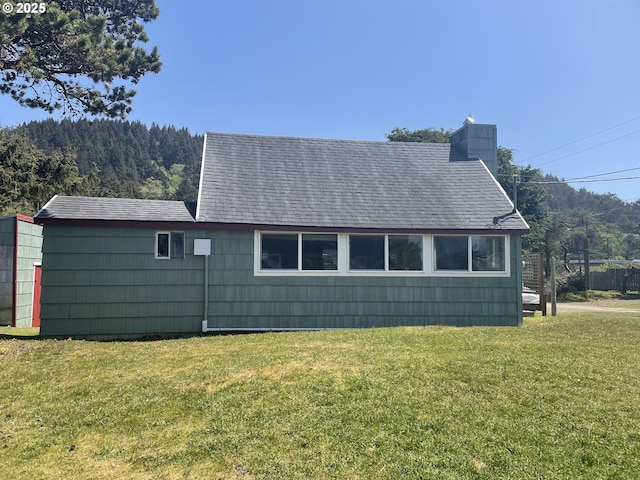 5870 Floyd Ave, Cloverdale, OR 97112 - view of home's exterior with a shingled roof, a chimney, and a lawn
