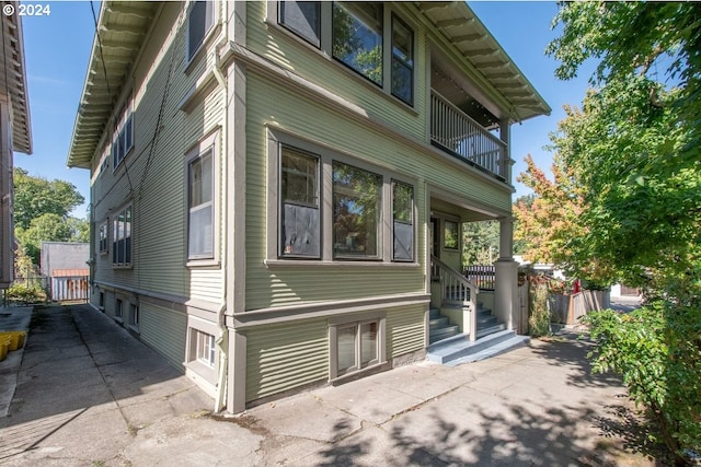 view of side of home with a balcony