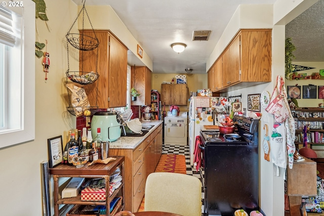 1304 NE 79th Ave, Portland, OR 97213 - kitchen with black electric range oven, washer / clothes dryer, light countertops, brown cabinets, and healthy amount of natural light