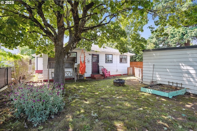 1304 NE 79th Ave, Portland, OR 97213 - back of house featuring entry steps, a vegetable garden, and a fenced backyard