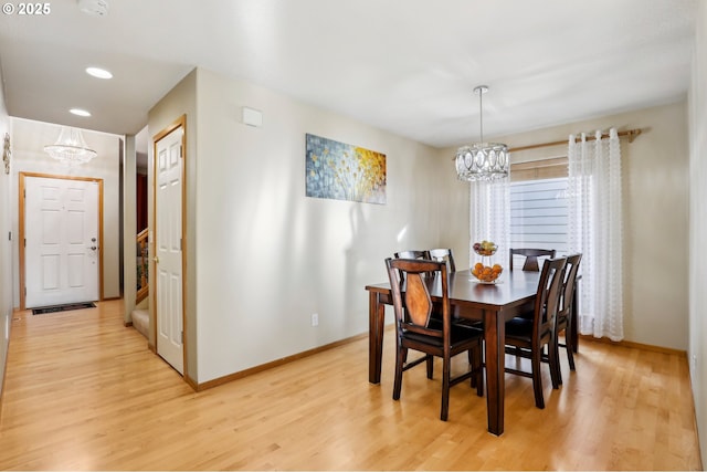 dining area featuring light wood-type flooring and a chandelier