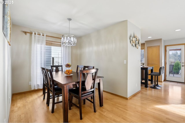 dining area with an inviting chandelier and light hardwood / wood-style floors