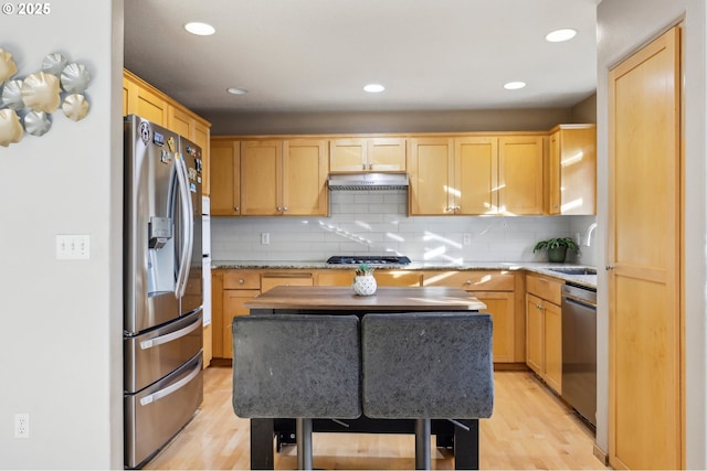 kitchen featuring sink, a kitchen island, stainless steel appliances, and light brown cabinets