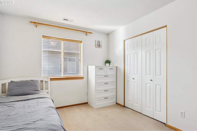 bedroom featuring a closet and light carpet