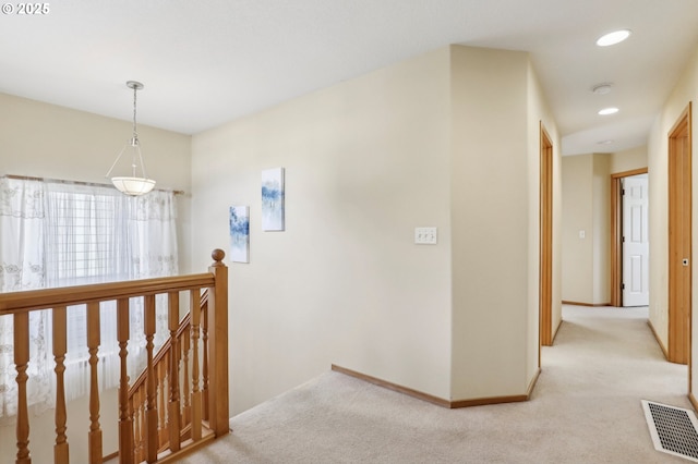 hall with light colored carpet