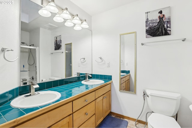 bathroom featuring vanity, an enclosed shower, and toilet