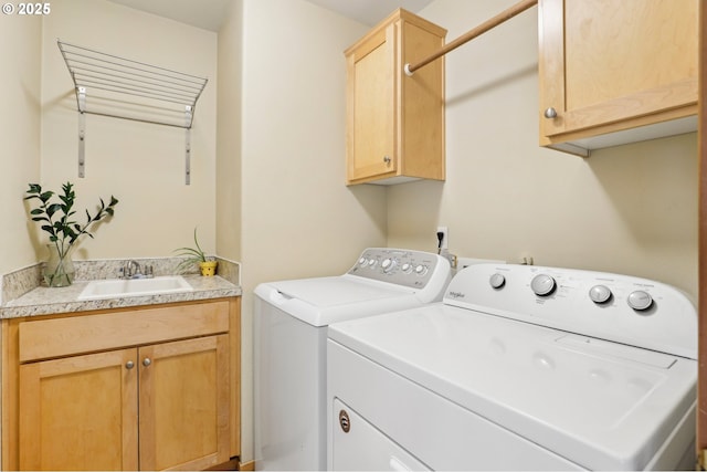 washroom featuring cabinets, sink, and washing machine and clothes dryer