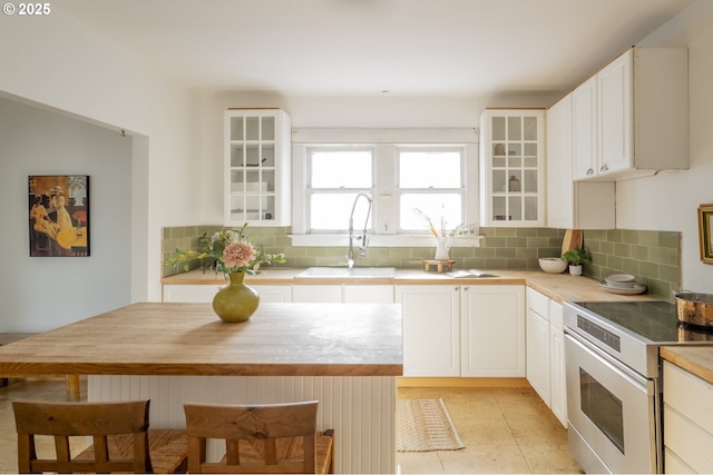 1818 N Killingsworth St, Portland, OR 97217 - kitchen with a sink, white range with electric stovetop, decorative backsplash, and wooden counters