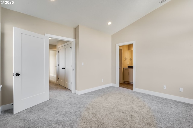 unfurnished bedroom featuring lofted ceiling, connected bathroom, recessed lighting, carpet flooring, and baseboards