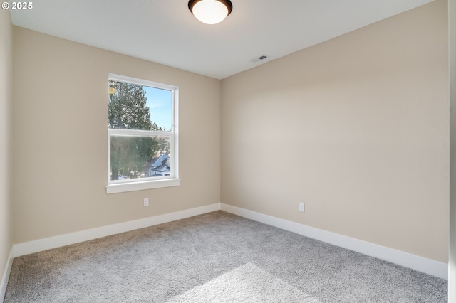 empty room featuring carpet, visible vents, and baseboards