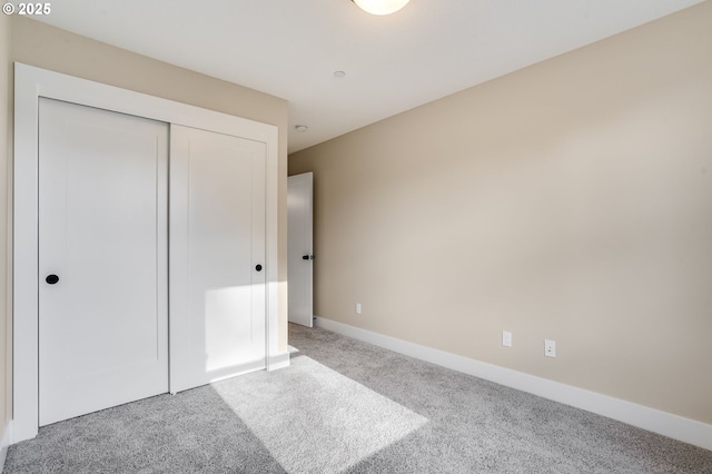 unfurnished bedroom featuring a closet, carpet, and baseboards