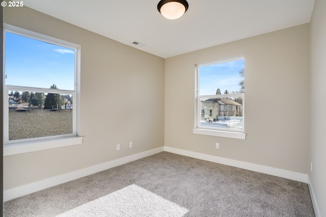 unfurnished room with baseboards, visible vents, and carpet flooring