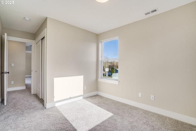 carpeted spare room with baseboards and visible vents