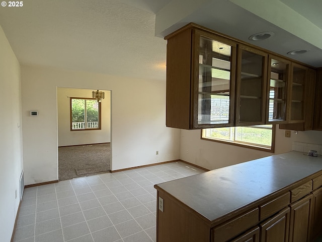 16117 NE 87th St, Vancouver, WA 98682 - kitchen featuring baseboards, light tile patterned floors, dark brown cabinetry, open floor plan, and glass insert cabinets
