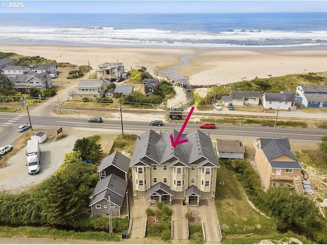 birds eye view of property featuring a water view and a beach view